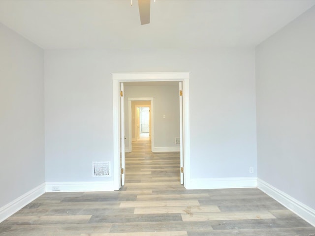 spare room featuring baseboards and wood finished floors