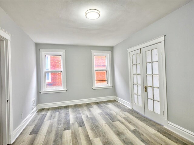 unfurnished room with baseboards and wood finished floors