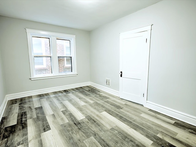 empty room featuring baseboards and wood finished floors