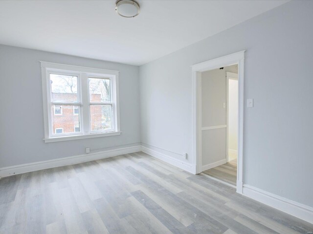 empty room with light wood-type flooring and baseboards