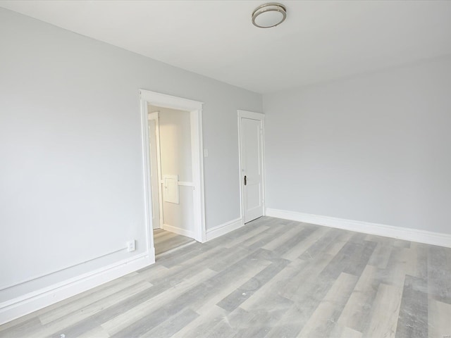 unfurnished room with light wood finished floors and baseboards