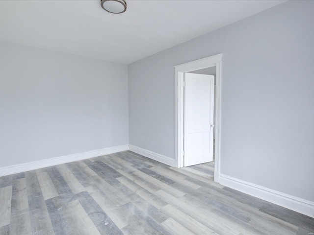 empty room with baseboards and wood finished floors