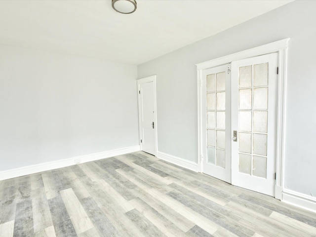 unfurnished room with light wood-type flooring and baseboards