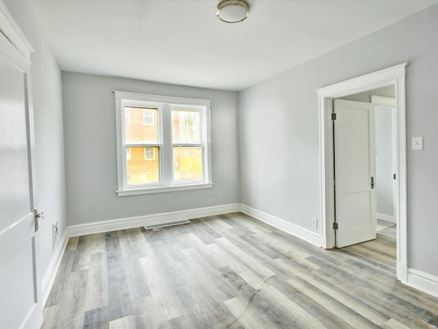 unfurnished room with baseboards and light wood-style floors