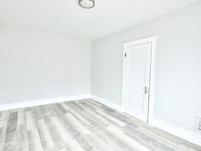 empty room featuring baseboards and wood finished floors