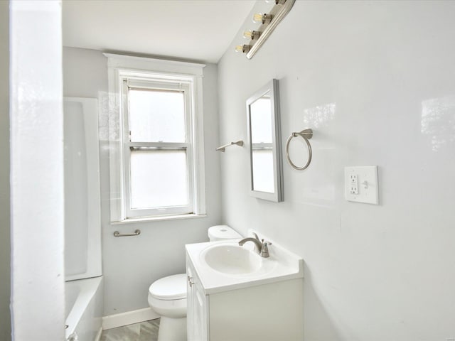 bathroom with vanity, toilet, plenty of natural light, and baseboards