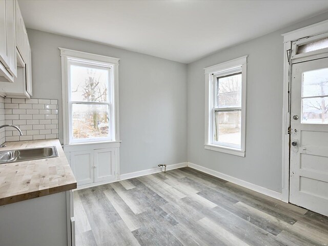 interior space featuring light wood-type flooring, baseboards, and a sink