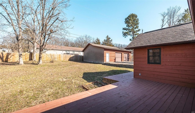 wooden deck featuring a yard, an outbuilding, and fence