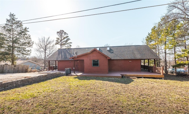 back of property with a shingled roof, fence, central AC, a yard, and a deck