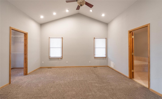 unfurnished bedroom featuring vaulted ceiling, a spacious closet, baseboards, and carpet floors