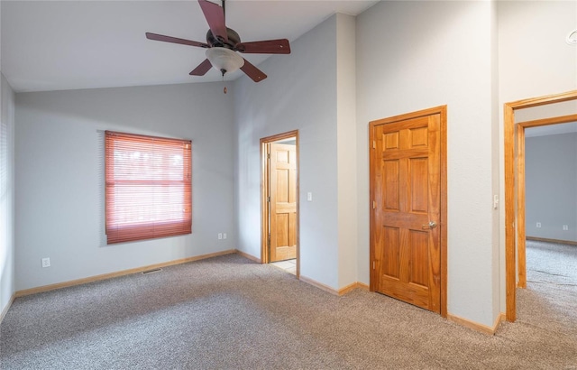 unfurnished bedroom featuring carpet flooring, high vaulted ceiling, and baseboards