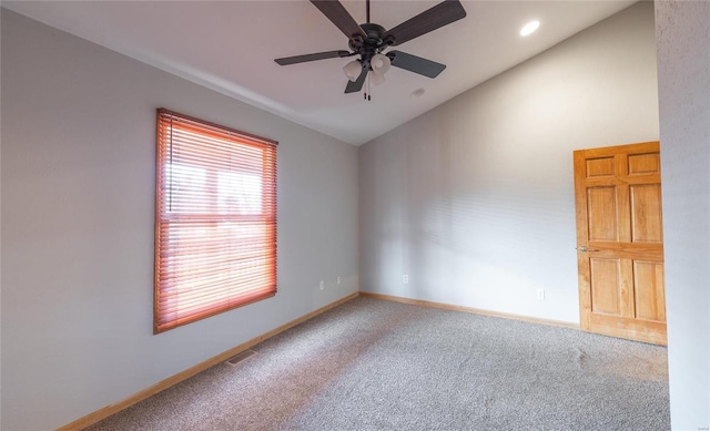 empty room featuring visible vents, ceiling fan, baseboards, carpet, and vaulted ceiling