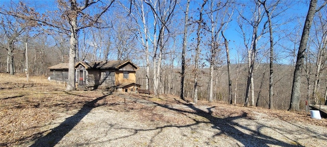 exterior space with a forest view and an outdoor structure