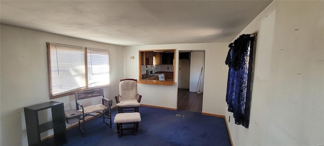 living area with carpet flooring, visible vents, and baseboards