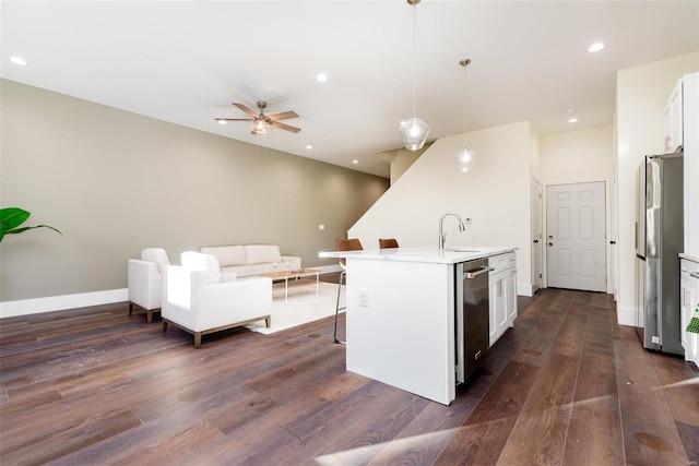 kitchen featuring dark wood finished floors, a kitchen breakfast bar, white cabinets, and appliances with stainless steel finishes