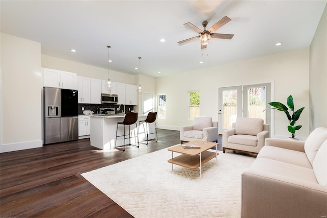 living room with ceiling fan, recessed lighting, dark wood-style flooring, and baseboards