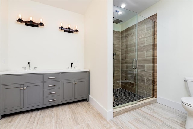 bathroom featuring a sink, baseboards, toilet, and a shower stall