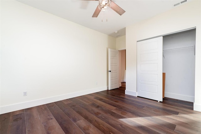 unfurnished bedroom featuring visible vents, dark wood finished floors, a closet, baseboards, and ceiling fan