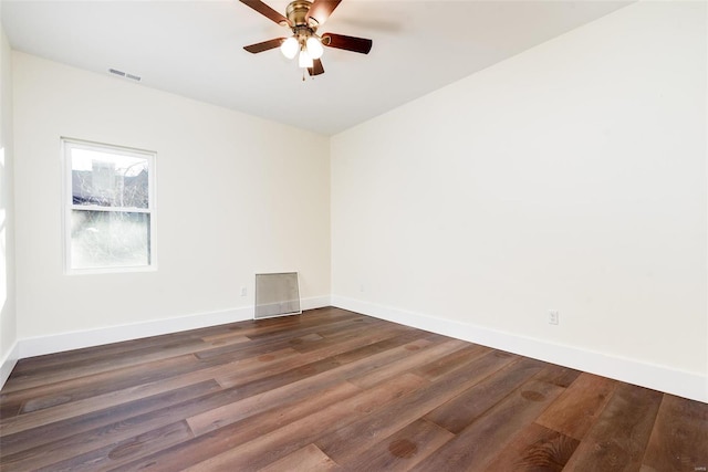 empty room featuring dark wood-style floors, visible vents, ceiling fan, and baseboards