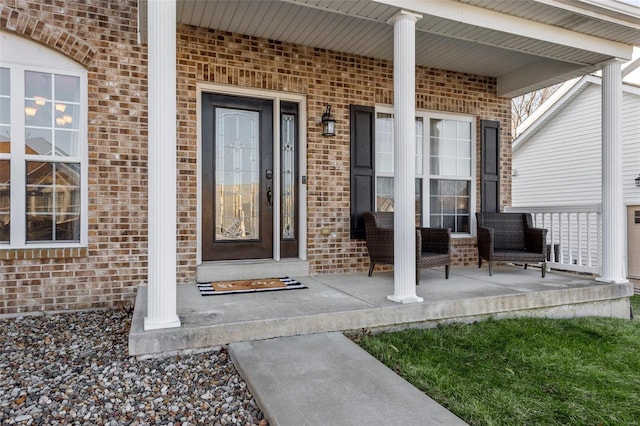 property entrance with brick siding and a porch