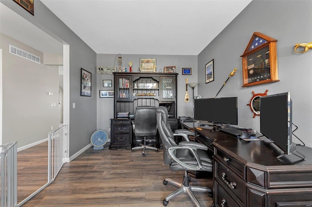 home office with visible vents, baseboards, and wood finished floors