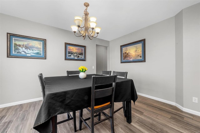 dining area featuring baseboards, an inviting chandelier, and wood finished floors