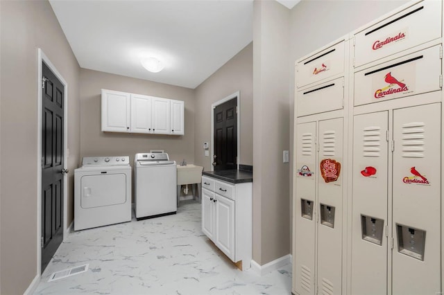 laundry room featuring baseboards, cabinet space, separate washer and dryer, a sink, and marble finish floor