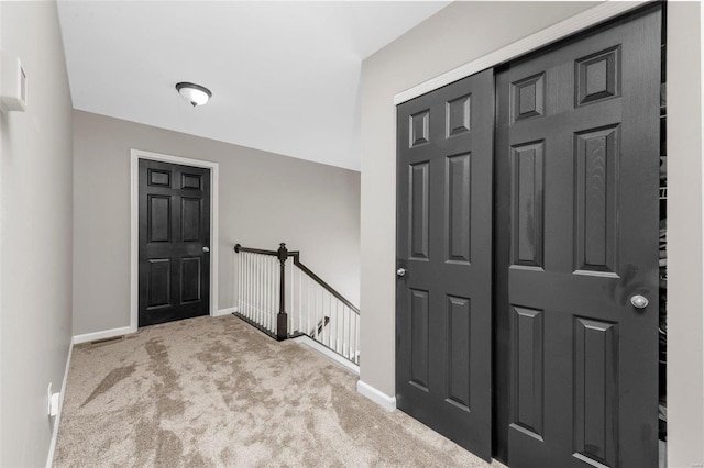 entryway with baseboards and carpet floors