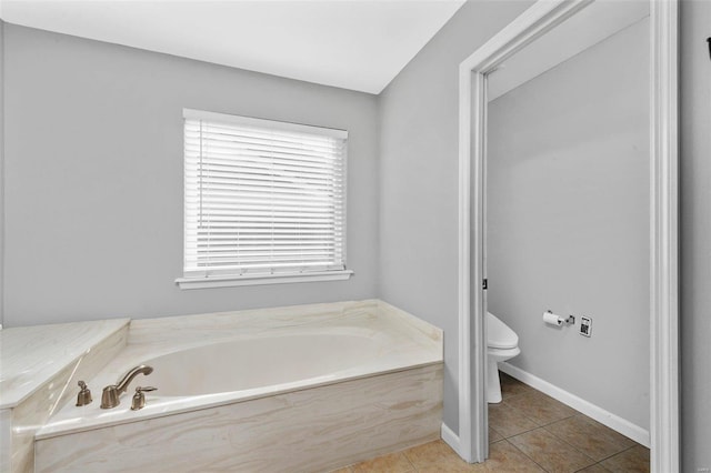 full bath with a garden tub, baseboards, toilet, and tile patterned flooring