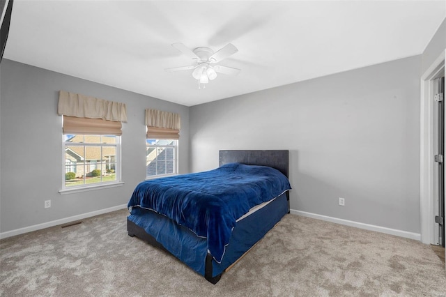 carpeted bedroom featuring visible vents, baseboards, and ceiling fan