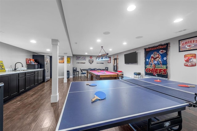 rec room with dark wood-style floors, recessed lighting, indoor wet bar, and a sink