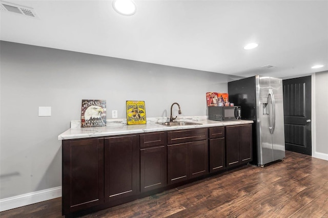 kitchen with visible vents, black microwave, stainless steel fridge with ice dispenser, dark wood finished floors, and a sink