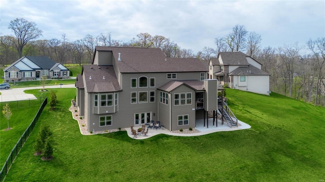 back of property featuring a lawn, fence, stairs, and a patio area