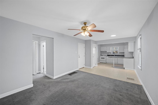 unfurnished living room with visible vents, baseboards, and light colored carpet