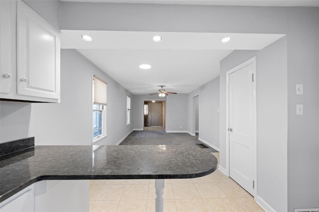 kitchen featuring dark countertops, white cabinets, light tile patterned flooring, and recessed lighting