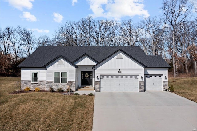 view of front of home with an attached garage, concrete driveway, a front lawn, and roof with shingles