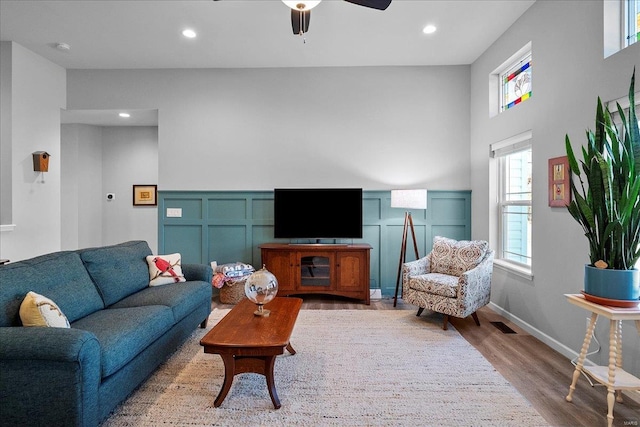 living area with a ceiling fan, recessed lighting, wood finished floors, and baseboards