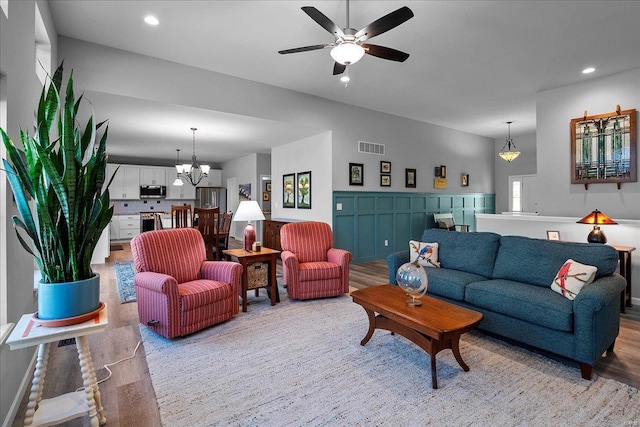 living area featuring visible vents, recessed lighting, ceiling fan with notable chandelier, and light wood-style flooring