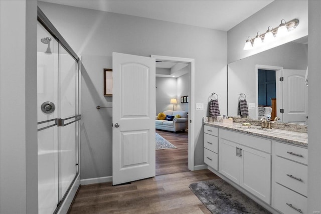 ensuite bathroom featuring wood finished floors, ensuite bath, and a shower stall