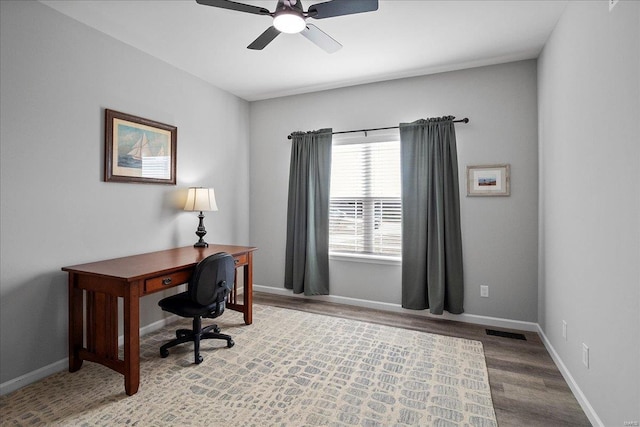 office featuring visible vents, a ceiling fan, baseboards, and wood finished floors