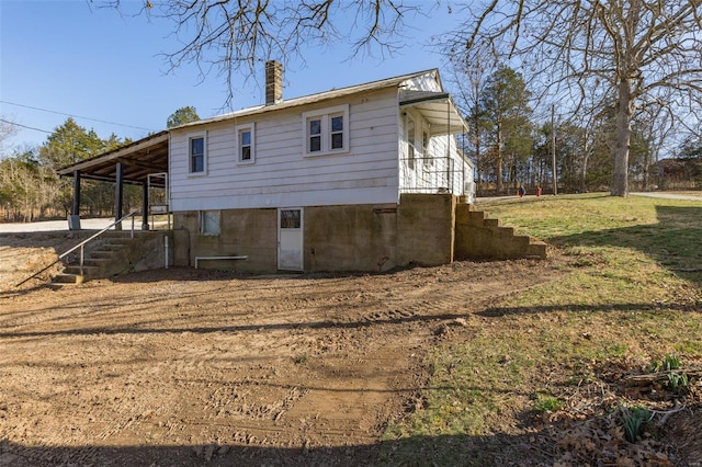 back of property featuring a lawn and a chimney