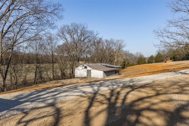 view of yard featuring an outbuilding and gravel driveway