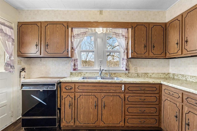 kitchen featuring crown molding, dishwasher, light countertops, brown cabinetry, and a sink