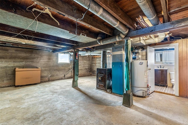 below grade area featuring gas water heater, heating unit, and a sink