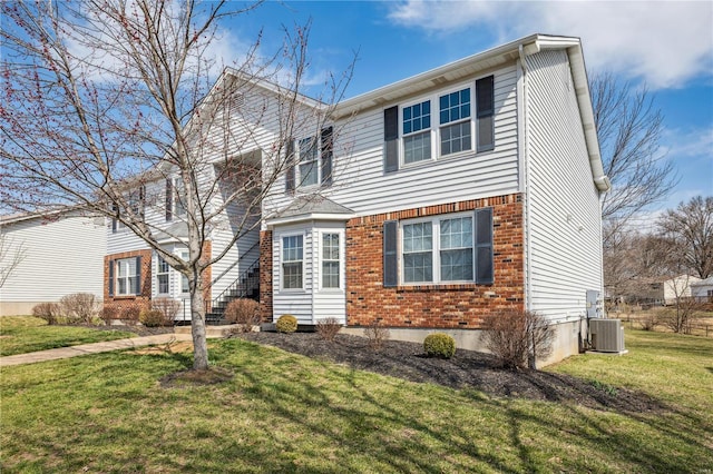 view of front of property featuring central air condition unit, brick siding, and a front lawn