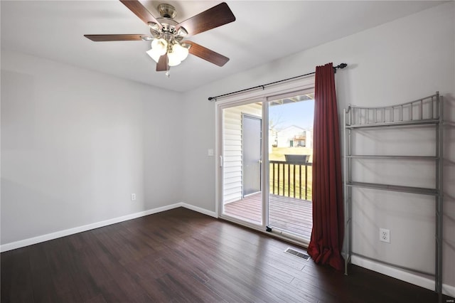 empty room featuring visible vents, a ceiling fan, baseboards, and dark wood-style flooring