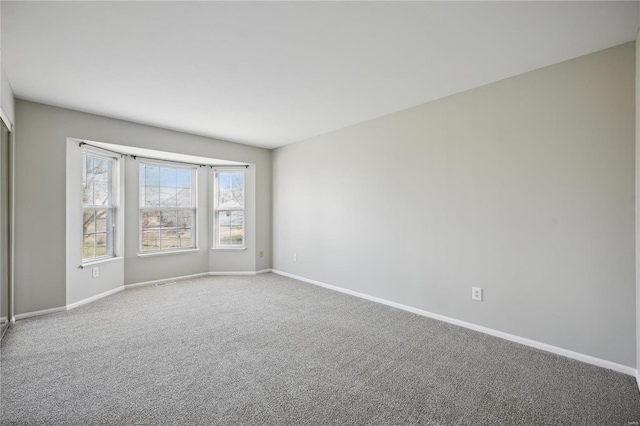 unfurnished room with baseboards and carpet