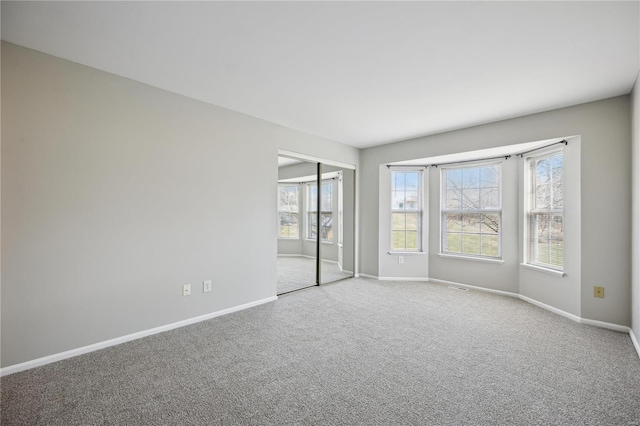 carpeted empty room with visible vents and baseboards