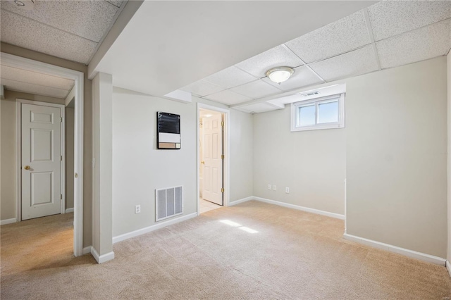 below grade area featuring carpet, a paneled ceiling, visible vents, and baseboards