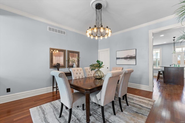 dining area featuring visible vents, wood-type flooring, baseboards, and crown molding